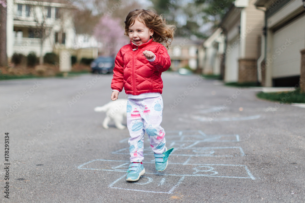 Cute toddler doing hopscotch outside Cute toddler doing hopscotch outside