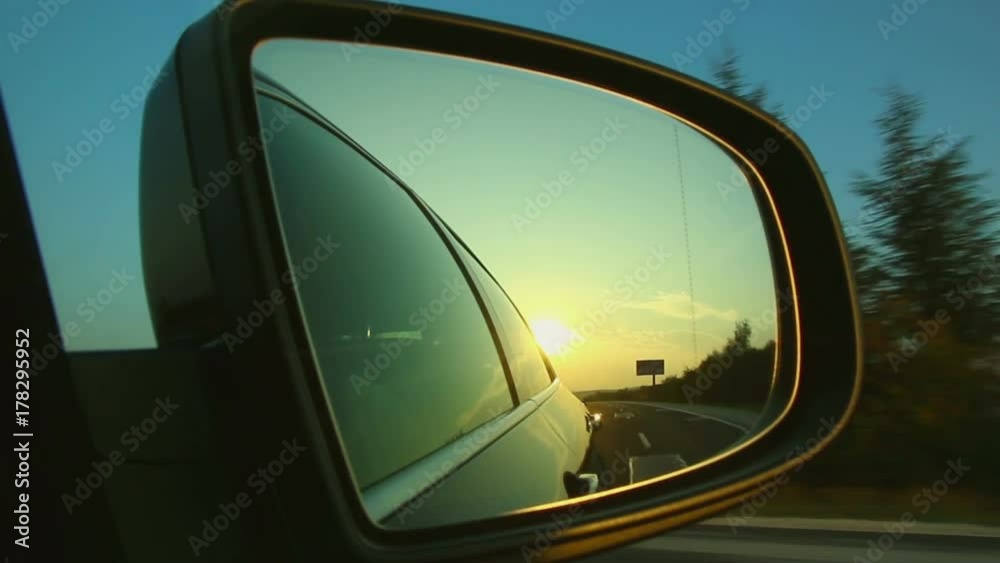 Highway road travel seen from side mirror with a sunrise sunset Highway road travel seen from side mirror with a sunrise sunset