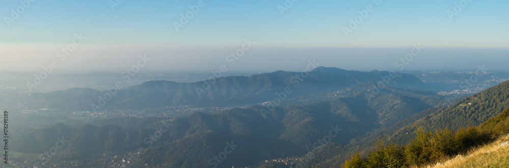 Fototapeta premium Morning landscape on the Padana plain with high pollution and humidity in the air. Panorama from Linzone Mountain, Bergamo, Italy