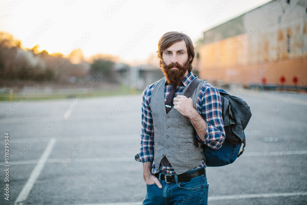 Portrait of a hip and trendy bearded man in a parking lot Portrait of a hip and trendy bearded man in a parking lot
