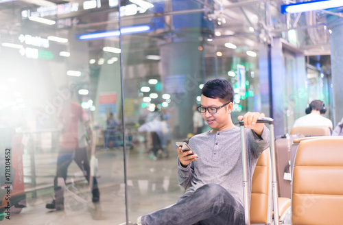 Asian man traveler using mobile phone in airport,Lifestyle using cell phone connection concept