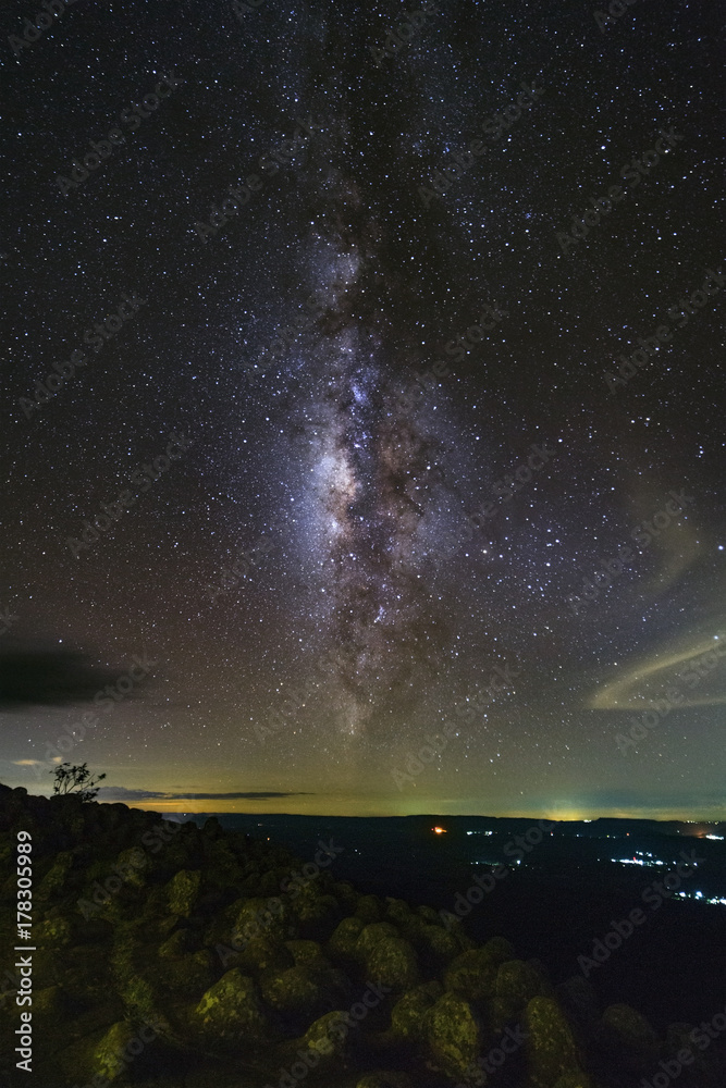Naklejka premium Milky way galaxy with knob stone ground is name Lan Hin Pum viewpoint at Phu Hin Rong Kla National Park in Phitsanulok, Thailand