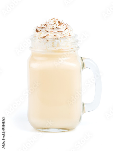 Eggnog with whipped cream and cinnamon in mason jar isolated on white. Homemade eggnog in mason jar isolated with clipping path
