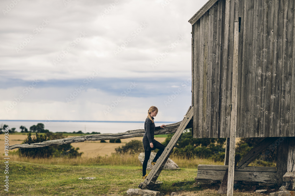 Woman climbing steps into wooden cabin Woman climbing steps into wooden cabin