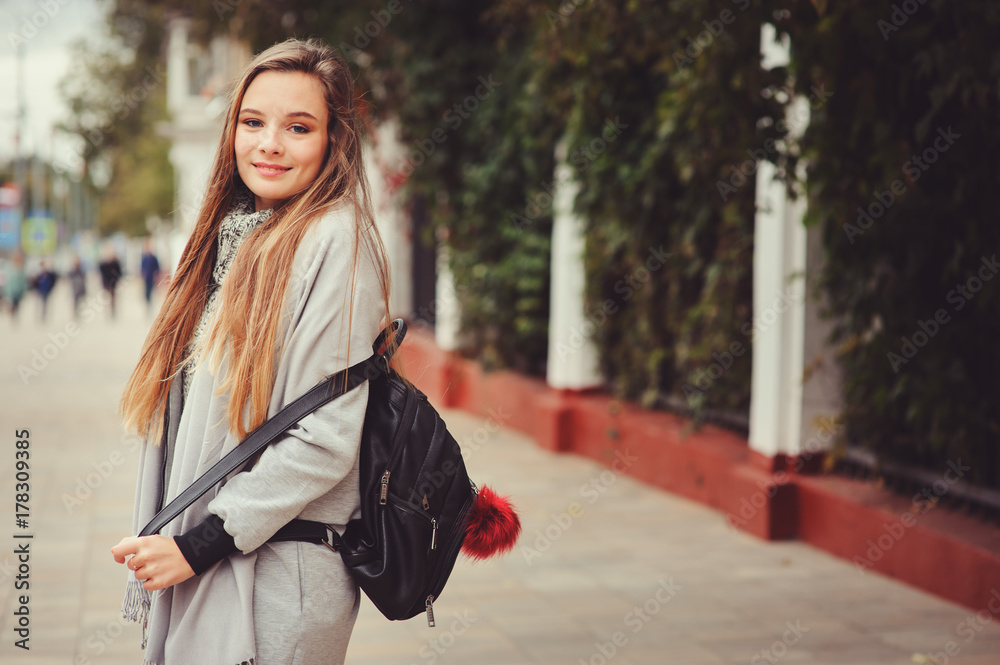street style portrait of young beautiful happy girl walking in autumn city with trendy leather backpack street style portrait of young beautiful happy girl walking in autumn city with trendy leather backpack
