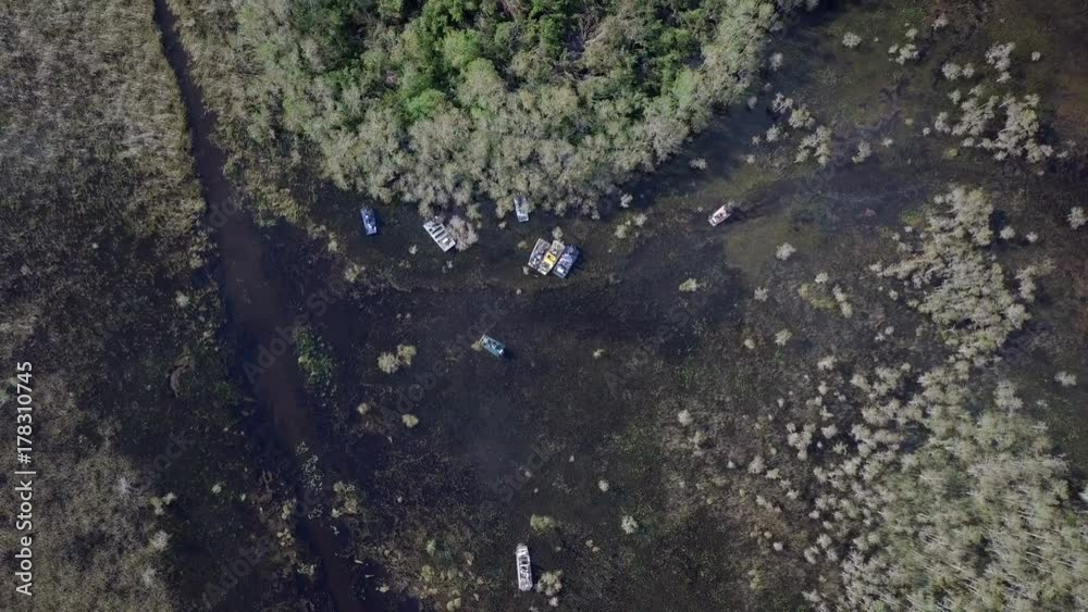 Aerial drone overhead wide shot of the Florida Everglades with some fan boats parked by a small island. Aerial drone overhead wide shot of the Florida Everglades with some fan boats parked by a small island.