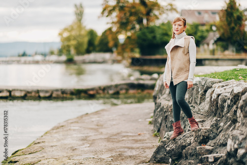 Outdoor portrait of pretty little girl resting by the lake on a cloudy day  image taken in Lausanne  Switzerland