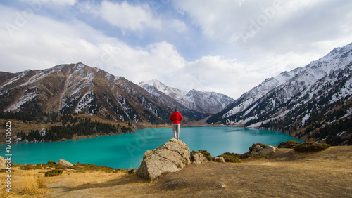 a girl stands on a mountain, a mountain lake © serikbaib