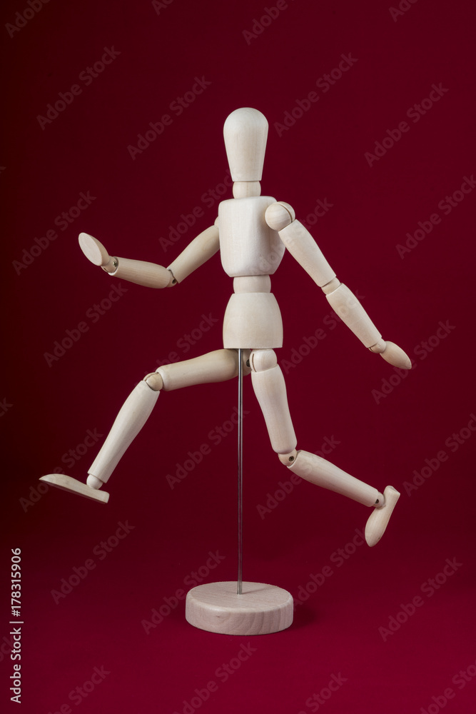 a wooden dummy walking with a red background a wooden dummy walking with a red background