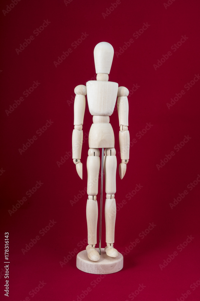 a wooden dummy posing with a red background a wooden dummy posing with a red background