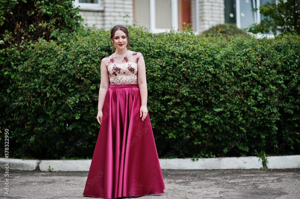 Portrait of a beautiful and gentle girl in elegant gown posing outdoor.