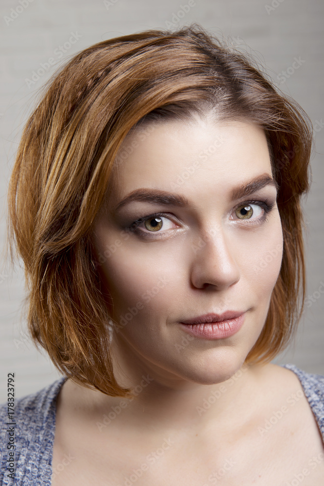 Naklejka premium Hairstyle Bob cut on red hair and evening makeup close-up portrait