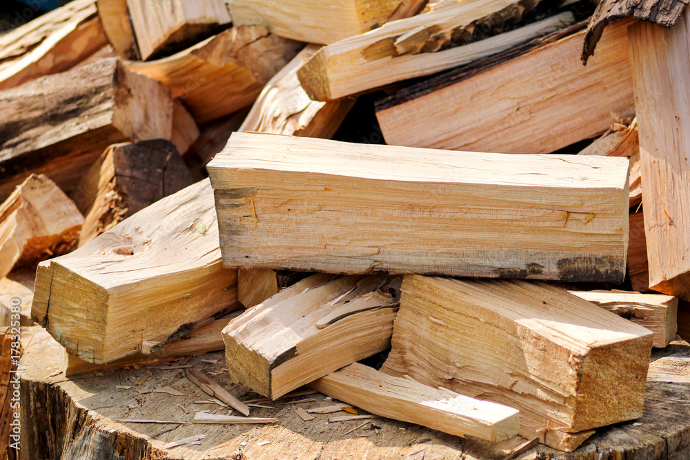A pile of chopped firewood logs ready for the winter. Cut logs fire wood. Hardwood, wood and lumber industry. Heating season, winter season. Renewable resource of energy. Environmental concept. A pile of chopped firewood logs ready for the winter. Cut logs fire wood. Hardwood, wood and lumber industry. Heating season, winter season. Renewable resource of energy. Environmental concept.