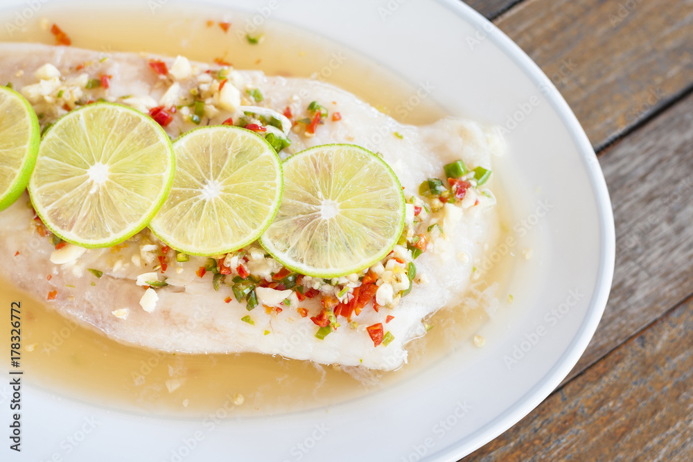 Steamed fish in lime on wooden table brown with thai style Steamed fish in lime on wooden table brown with thai style