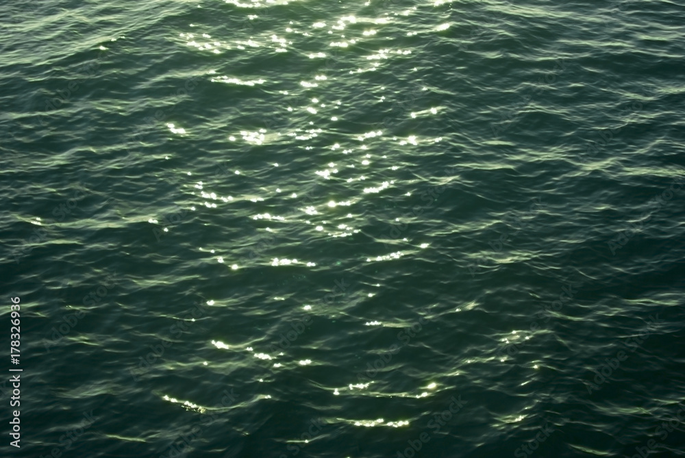 background, texture: sea water surface with sunlight reflections in the evening illumination background, texture: sea water surface with sunlight reflections in the evening illumination