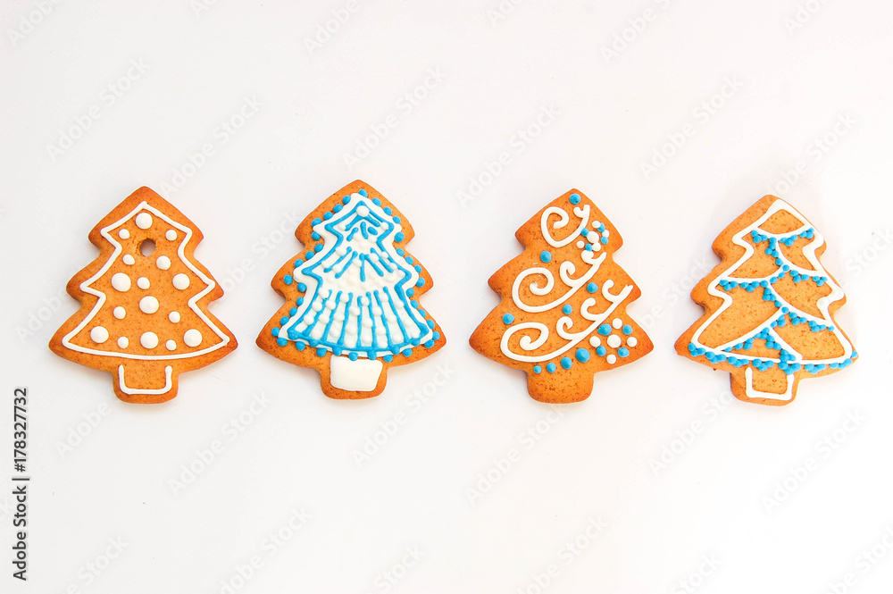 Ginger delicious gingerbread in the form of snowflakes and fir trees, isolated on white background. Holiday gift

