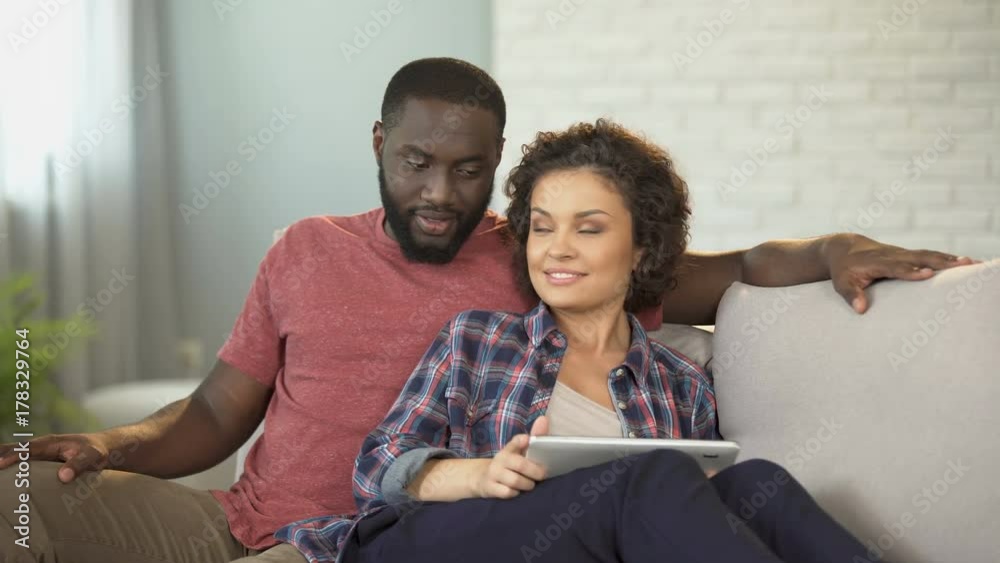 Mixed-race couple planning vacation on Internet, easy tickets and hotel booking Mixed-race couple planning vacation on Internet, easy tickets and hotel booking