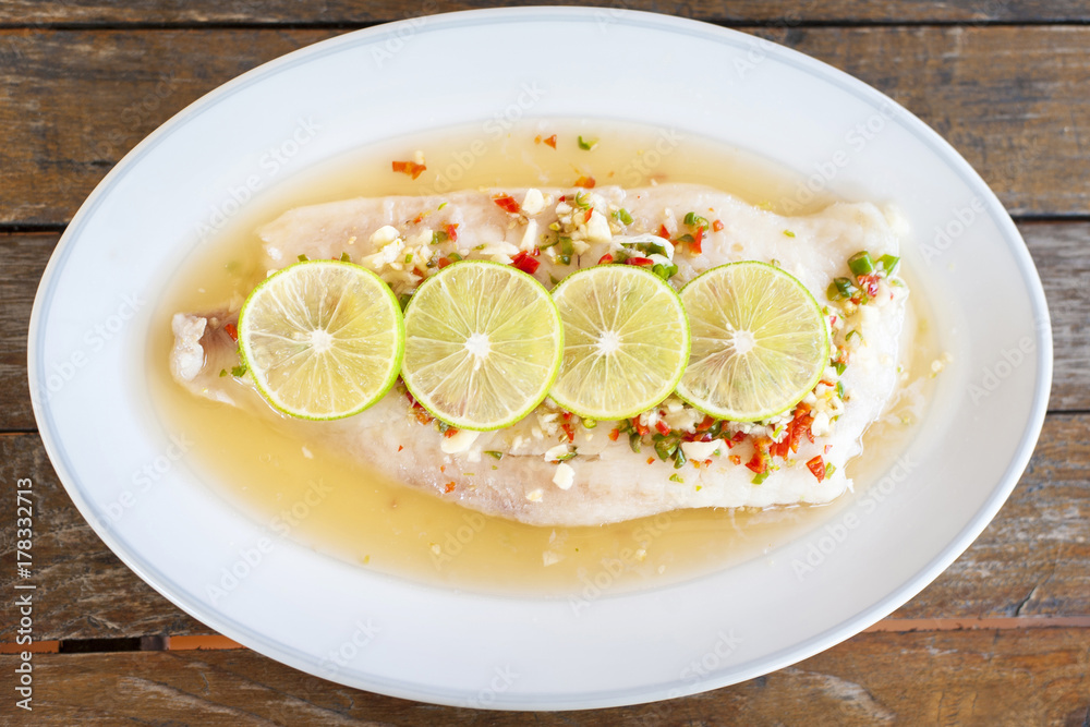 Steamed fish in lime on wooden table brown with thai style Steamed fish in lime on wooden table brown with thai style