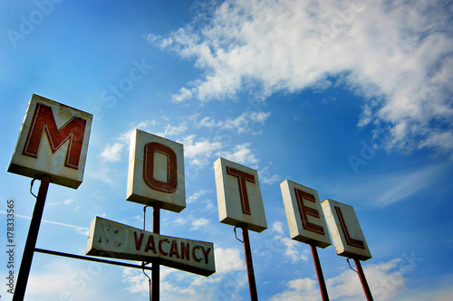 vintage motel sign against a cloudy sky. photo