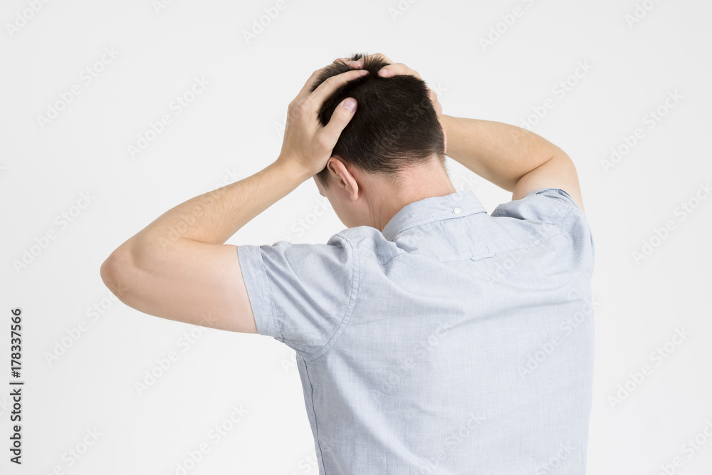 Headache and migraine, man with head pain on gray background Headache and migraine, man with head pain on gray background