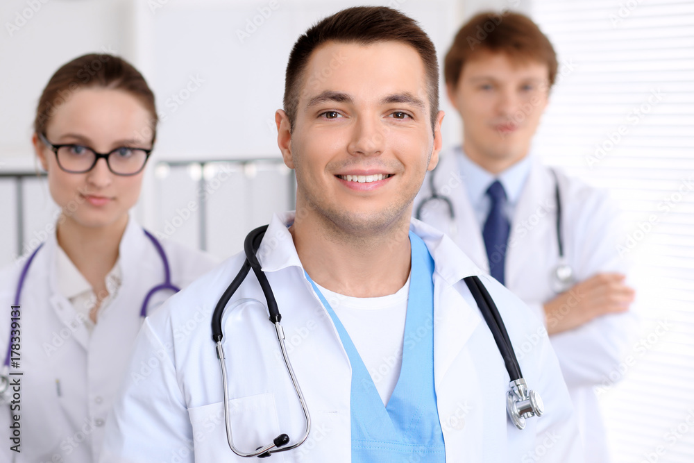 Cheerful smiling male doctor with medical staff at the hospital Cheerful smiling male doctor with medical staff at the hospital