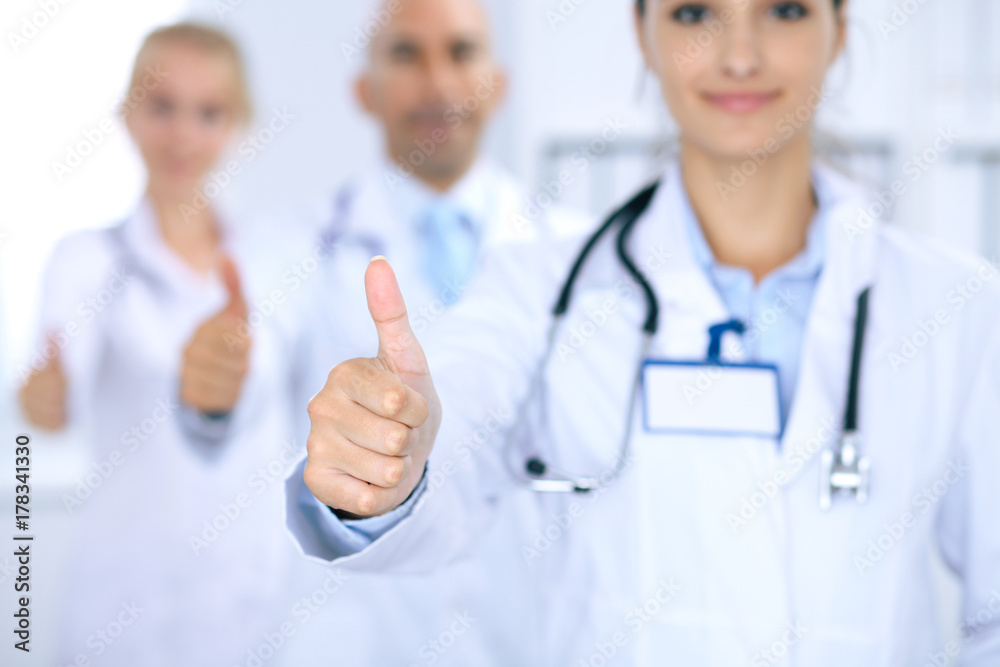 Group of doctors showing OK or approval sign with thumb up. High level and quality medical service, best treatment and patient care concept Group of doctors showing OK or approval sign with thumb up. High level and quality medical service, best treatment and patient care concept