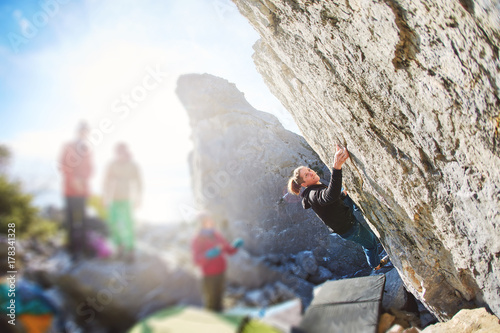female rock climber climbs on a rocky wall. winter bouldering session