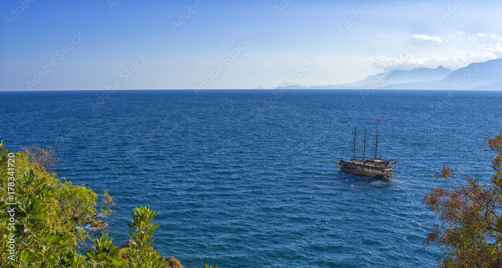 Panoramic view on Mediterranean sea and a sailing ship. Antalya, Turkey