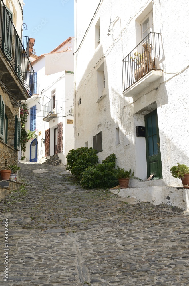 Cobblestone alley slope in Cadaques, Girona, Spain.