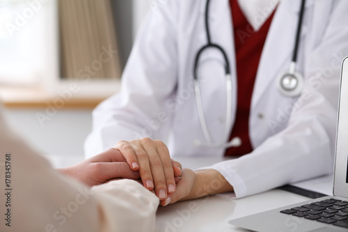 Hand of doctor  reassuring her female patient