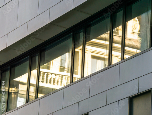 Modern reflecting facade with the mirror image of old buildings from the penultimate century