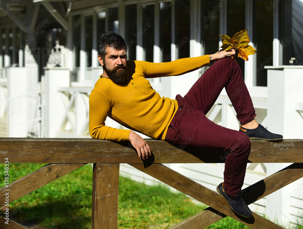Guy with beard lies on handrail. Man with confident face Guy with beard lies on handrail. Man with confident face