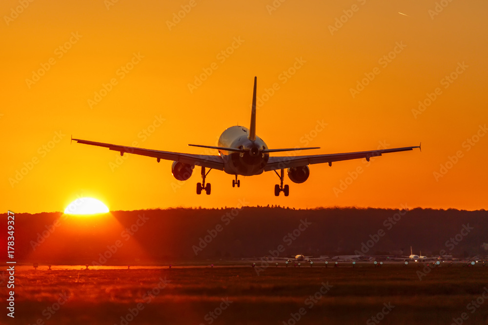 Fototapeta premium Samolot ląduje lotnisko latające słońce zachód słońca wakacje podróż podróży