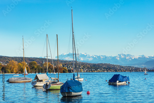 Boats on Lake Zurich in Switzerland in the evening, summits of the Alps in the background