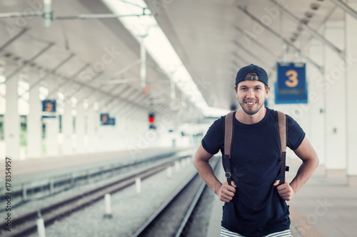 Young traveler walking with backpack on train station photo