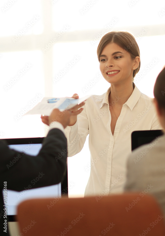 senior Manager, handing the employee a document with financial data. senior Manager, handing the employee a document with financial data.