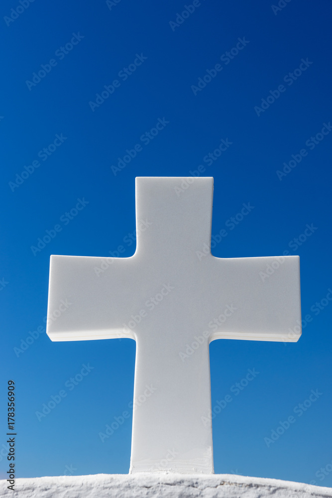 Weißes Kreuz vor blauen Himmel in Fira, Santorin 
