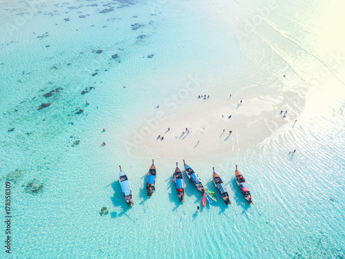 Top view or aerial view of longtail boats on crystal clear water along the sand beach in Phuket Thailand