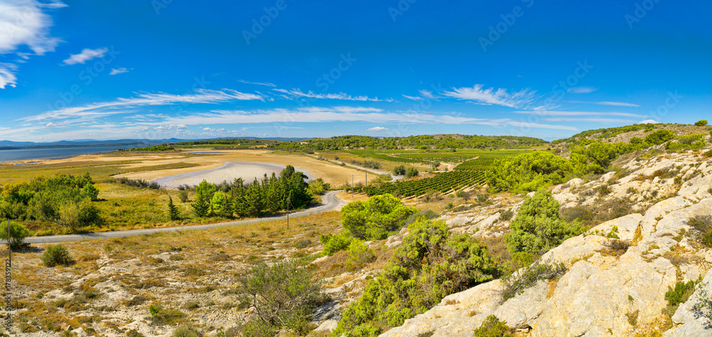 Panoramabild von der wunderschönen Landschaft in der Region um die kleine französische Ortschaft Gruissan mit seinen Hügeln, Felsen und Weinreben und dem Blick auf das Mittelmeer in Südfrankreich Panoramabild von der wunderschönen Landschaft in der Region um die kleine französische Ortschaft Gruissan mit seinen Hügeln, Felsen und Weinreben und dem Blick auf das Mittelmeer in Südfrankreich