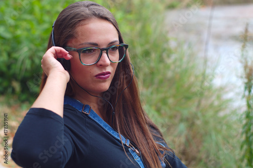 young women listening to music outside in the park