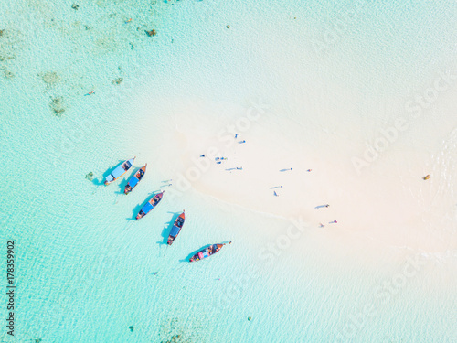 Top view or aerial view of longtail boats on crystal clear water along the sand beach in Phuket Thailand