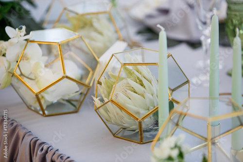 Cubes with white flowers stand on dinner table for newlyweds