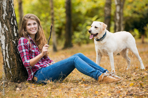 Beautiful autumn woman with Labrador dog