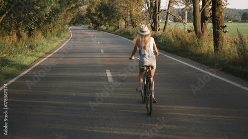 Wallpaper Mural a young blonde girl in pants on retro bike going down the road in the field Torontodigital.ca
