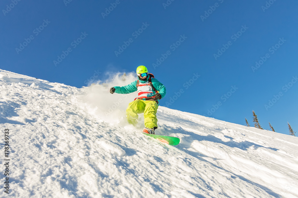 Freeride snowboarder slides down a steep slope at dawn