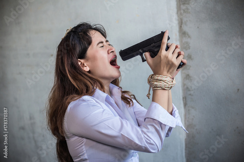 Business women use small guns at their mouths to kill themselves.