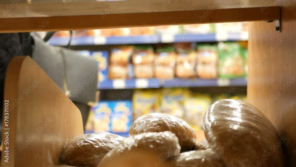 Woman buying fresh bread in a supermarket mall