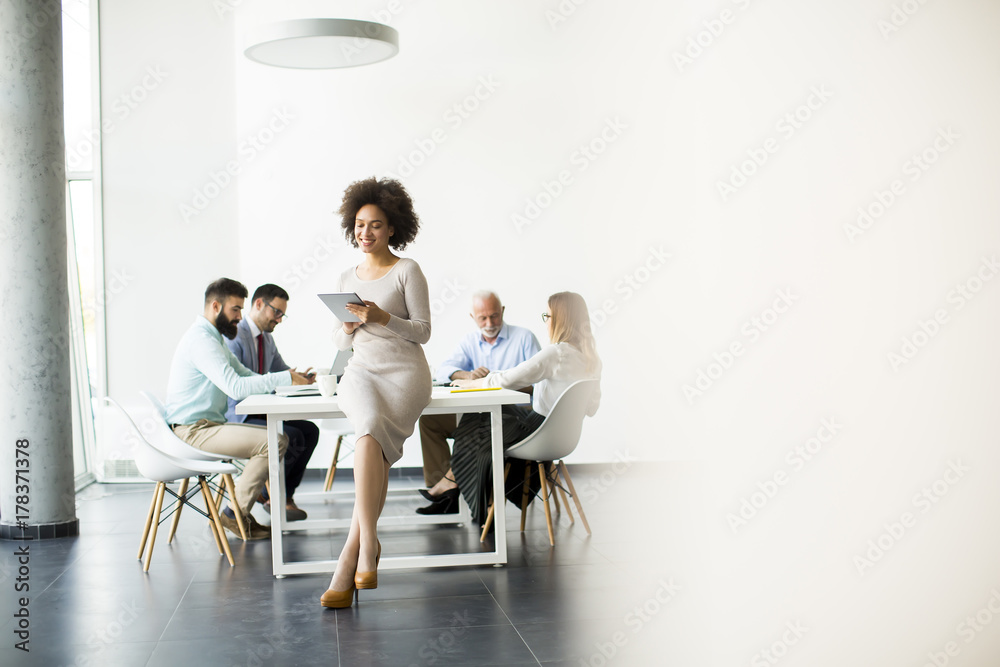 Smiling African woman using a tablet in office