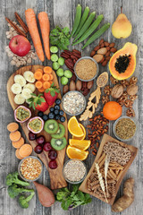 Health food concept for a high fibre diet with fruit, vegetables, cereals, nuts, seeds, whole wheat pasta, grains, legumes and spice. Foods high in omega 3, anthocyanins and antioxidants,  top view.