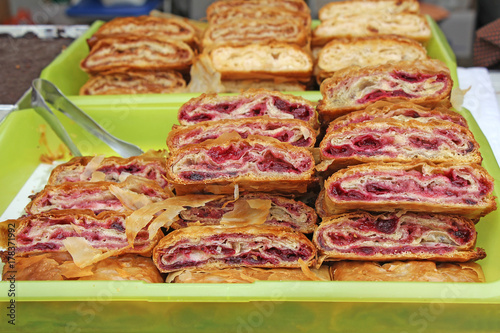 Sliced homemade strudel with cherry in streat market